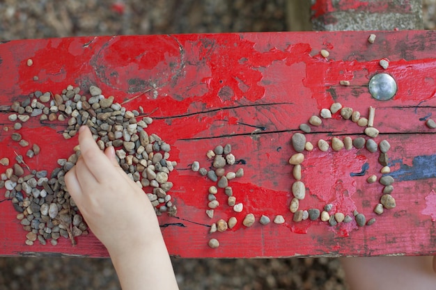 Kind speelt met kiezelstenen componeert uit stenen foto's concept