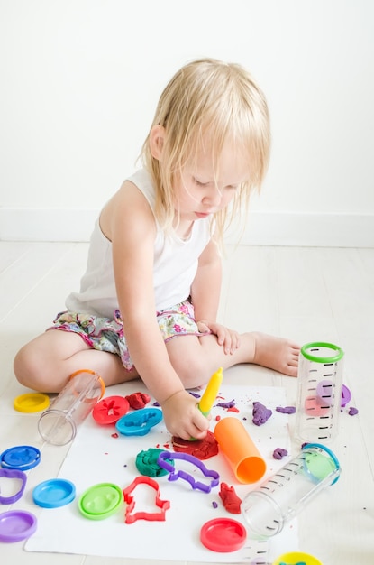 kind speelt met kleurrijke plastiline op de kleuterschool