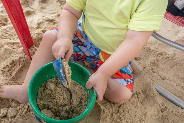 kind speelt met strandzand met plastic materialen