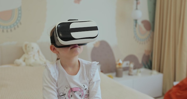 Foto kind speelt spelletjes op een virtual reality-apparaat meisje leert met behulp van een virtual reality headset