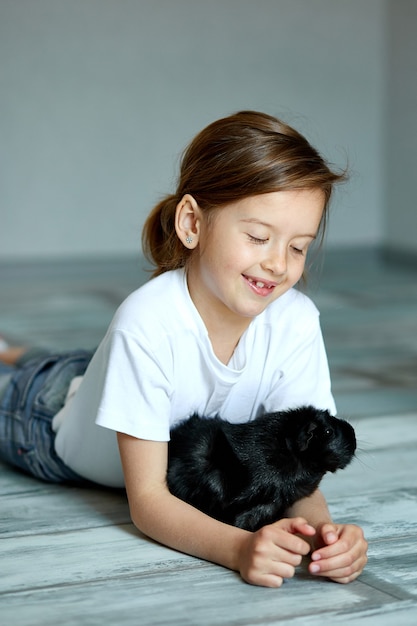 Kind spelen met cavia. Het meisje zorgt voor huisdieren.