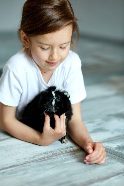 Kind spelen met cavia. Het meisje zorgt voor huisdieren.