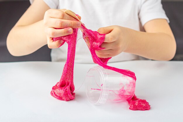 Kind spelen met zelfgemaakte roze glitter slijm