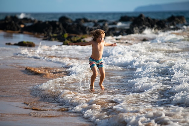 Kind spelen op oceaan strand kind springen in de golven op zee vakantie kleine jongen draait op tropische...