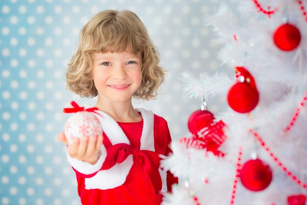 Kind spelen thuis. Kerstboom. Kerst vakantie concept