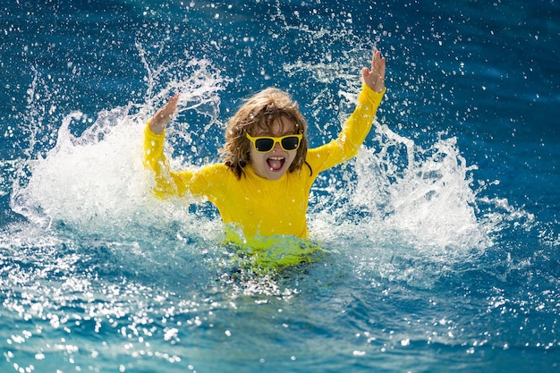 Kind spetteren in de zomer water zwembad Kid plons in zwembad opgewonden gelukkig jongetje springen in zwembad wat