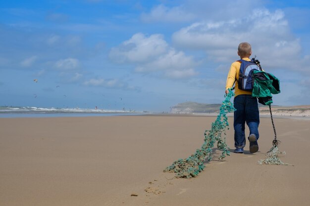 Kind staat aan zee en kijkt naar de horizon