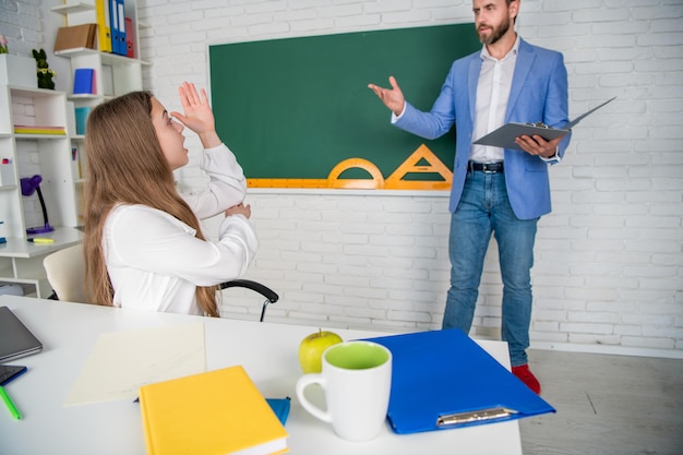 Kind stak de hand op in de klas met selectieve focus van de leraar