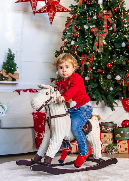 Kind te paard in de buurt van de kerstboom Selectieve aandacht