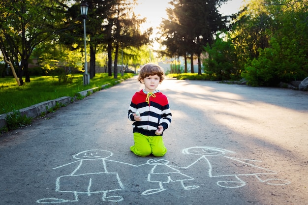 Kind tekent op asfalt.