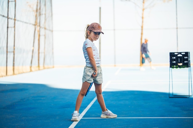 Kind tennissen op buitenbaan