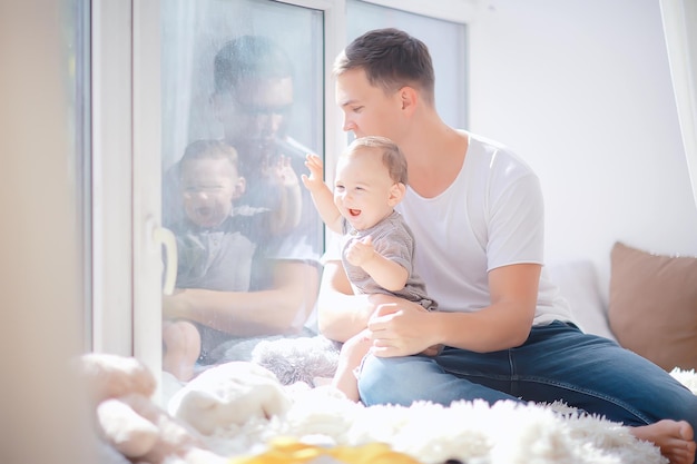 kind toont duim/peuter en papa bij het raam, zorg succes gezondheid gezin