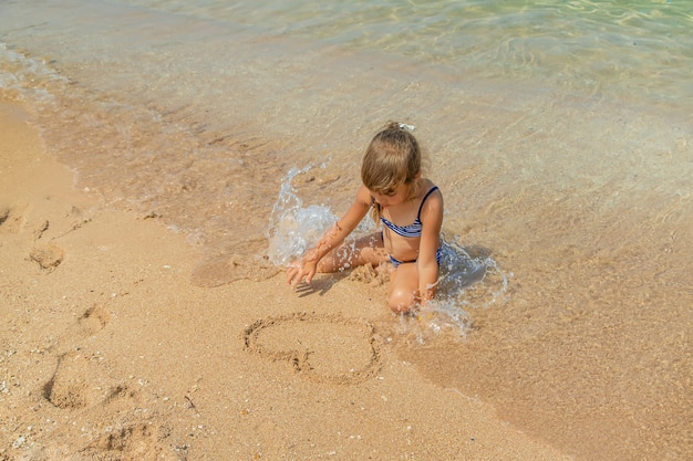 Kind trekt in het zand op het strand