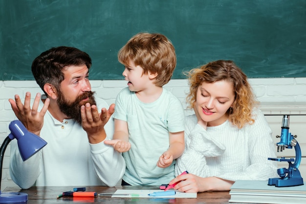 Kind van de basisschool met ouders in school onderwijsproces onderwijs gelukkig jong stel