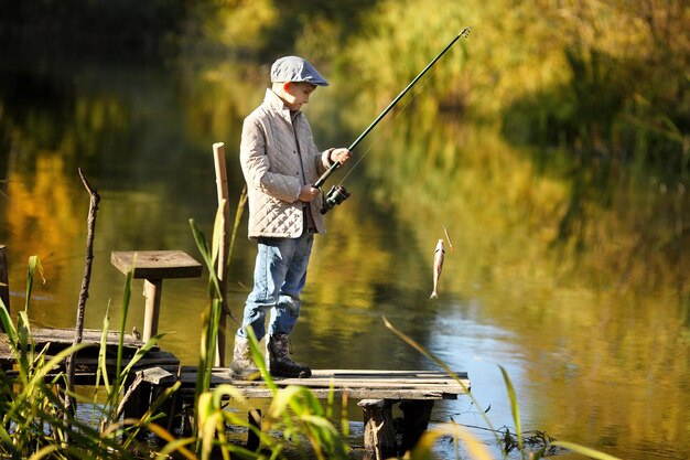 Kind vissen in een rivier zittend op een houten ponton