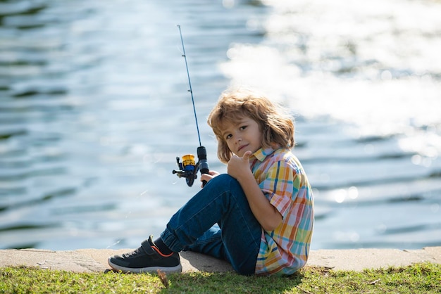 Foto kind vissen op de rivier jonge jongen visser zomer vrijetijdsbesteding in de buitenlucht kleine jongen vissen op de oever van de rivier met hengel