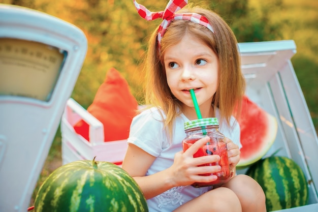 Kind watermeloen limonade drinken in pot met ijs en munt als zomer verfrissend drankje. Koude frisdrank met fruit