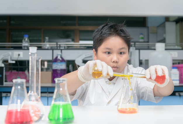 kind wetenschapper in laboratoriumjas maken van experiment