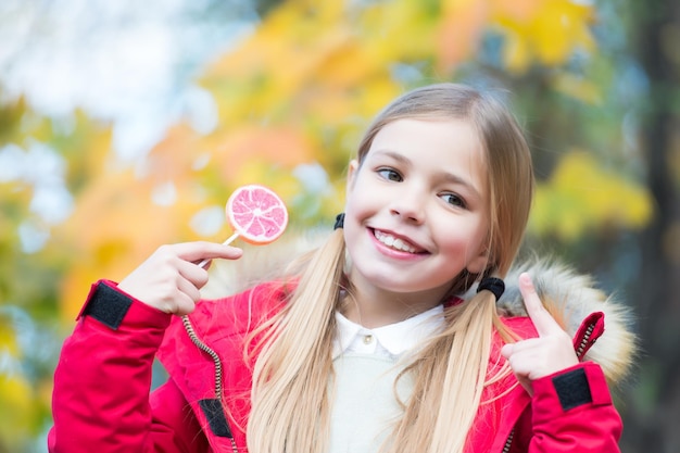 Kind wijst met de vinger naar snoep op stok buiten