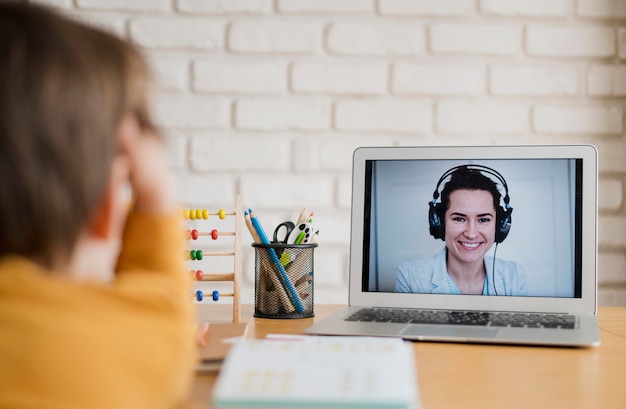 Foto kind wordt thuis bijles gegeven via online les