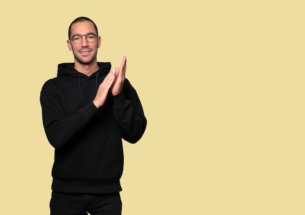 Kind young man doing an applauding gesture