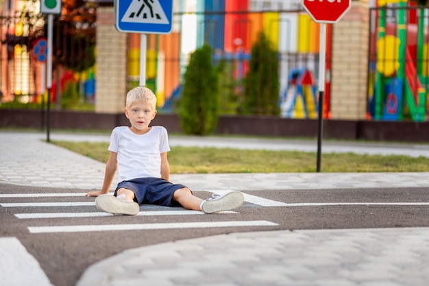 Kind zittend op de weg bij een zebrapad