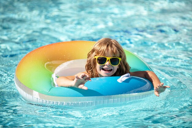 Kind zomervakantie Zomer Kind in zwembad Jongen zwemmen in aquapark Grappige jongen op opblaasbare rubberen cirkel