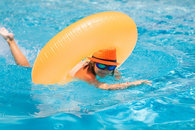 Kind zwemt op ring drijvend in blauw zwembad Opblaasbare ringsteun kids concept