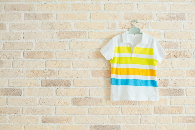 Kinder t-shirt met strepen op de hanger aan de muur