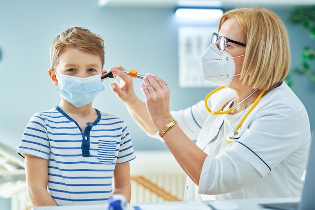 Kinderarts arts die kleine kinderen onderzoekt in de orencontrole van de kliniek. Hoge kwaliteit foto