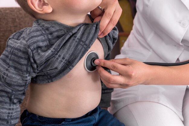 Kinderarts luisteren naar hartslag van kleine jongen