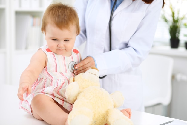 Kinderarts zorgt voor baby in het ziekenhuis Klein meisje onderzoekt door arts met stethoscoop Gezondheidszorgverzekering en hulpconcept