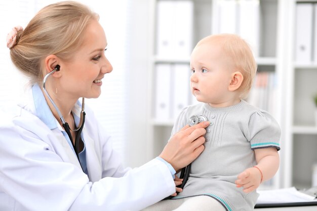 Kinderarts zorgt voor baby in het ziekenhuis. Klein meisje wordt onderzocht door een arts met een stethoscoop. Gezondheidszorg, verzekering en hulpconcept.