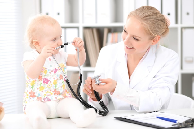 Kinderarts zorgt voor baby in het ziekenhuis. Klein meisje wordt onderzocht door een arts met een stethoscoop. Gezondheidszorg, verzekering en hulpconcept.