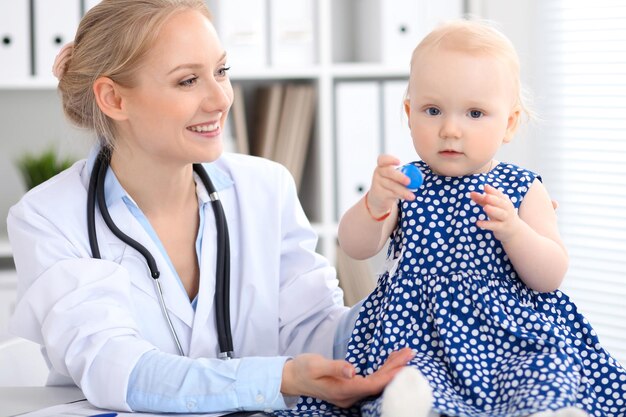 Kinderarts zorgt voor baby in het ziekenhuis. klein meisje wordt onderzocht door een arts met een stethoscoop. gezondheidszorg, verzekering en hulpconcept.
