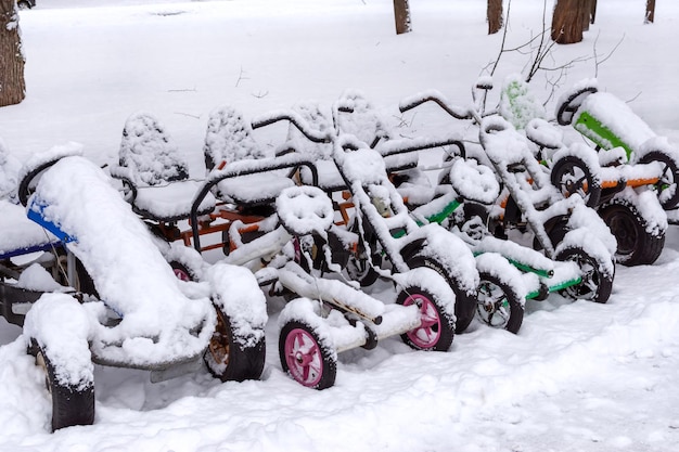 Kinderauto's zijn in de winter bedekt met een dikke laag sneeuw