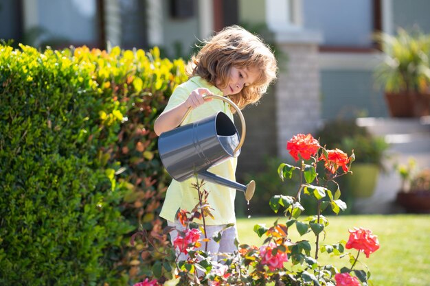 Kinderboer met gieter in tuin bloemen planten