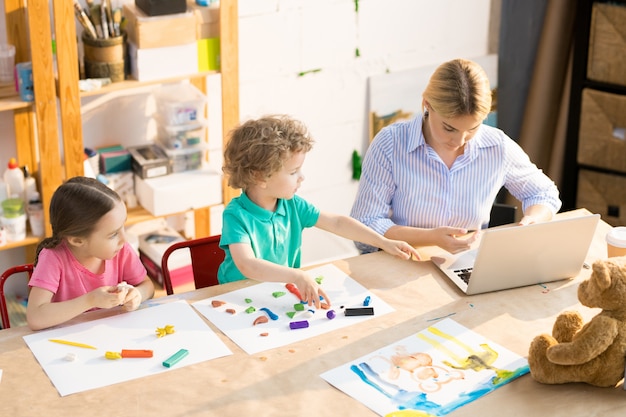 Kinderen boetseerklei in de klas