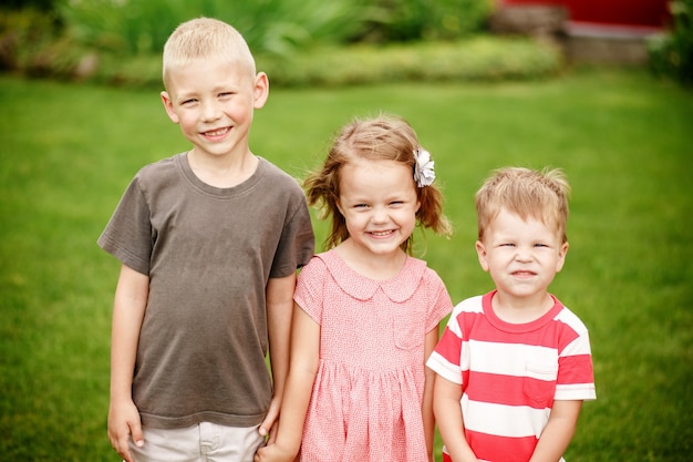 Kinderen buiten in de zomer op het gras in de achtertuin