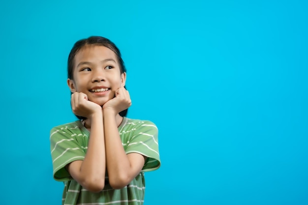 Kinderen close-up foto van schattige en vrolijke mensen, kijken en glimlachen op blauwe pastel achtergrond