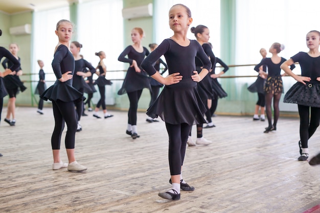 Kinderen dansen met een trainer in een grote trainingsruimte.