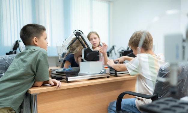 Kinderen die de handrobottechnologie gebruiken Studenten bestuderen technologie, wat een van de STEM-cursussen is