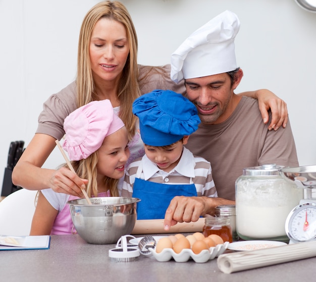 Kinderen die koekjes bakken met hun ouders