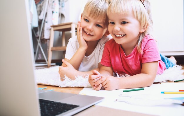 Foto kinderen die online computertechnologie gebruiken om creatief te tekenen of te knutselen