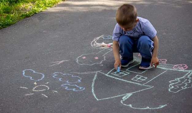 Kinderen die op het huis van de asfaltfamilie trekken. Selectieve focus