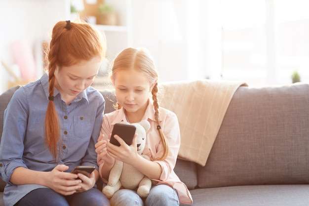 Kinderen die smartphones thuis gebruiken