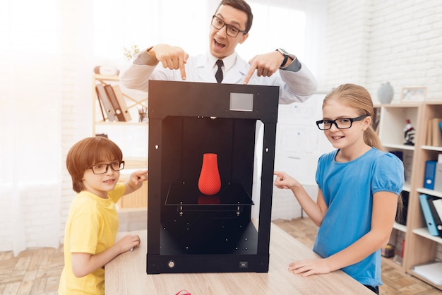 Kinderen die zich voordeed op camera met leraar en 3d-printer.