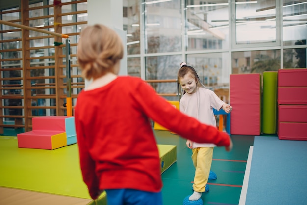 Kinderen doen massage-egel voor voetbenenoefeningen in de sportschool op de kleuterschool of basisschool. Kinderen sport en fitness concept.