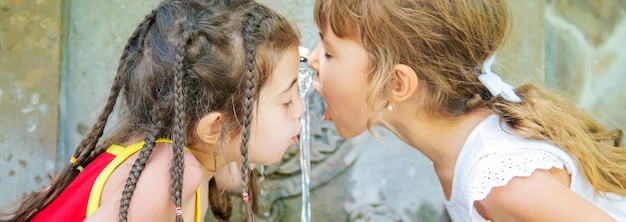 Kinderen drinken water uit een bron in Borjomi, Georgia.