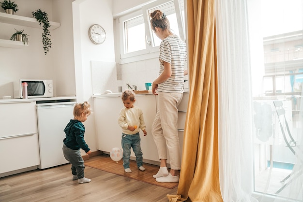 Kinderen en hun moeder in de keuken